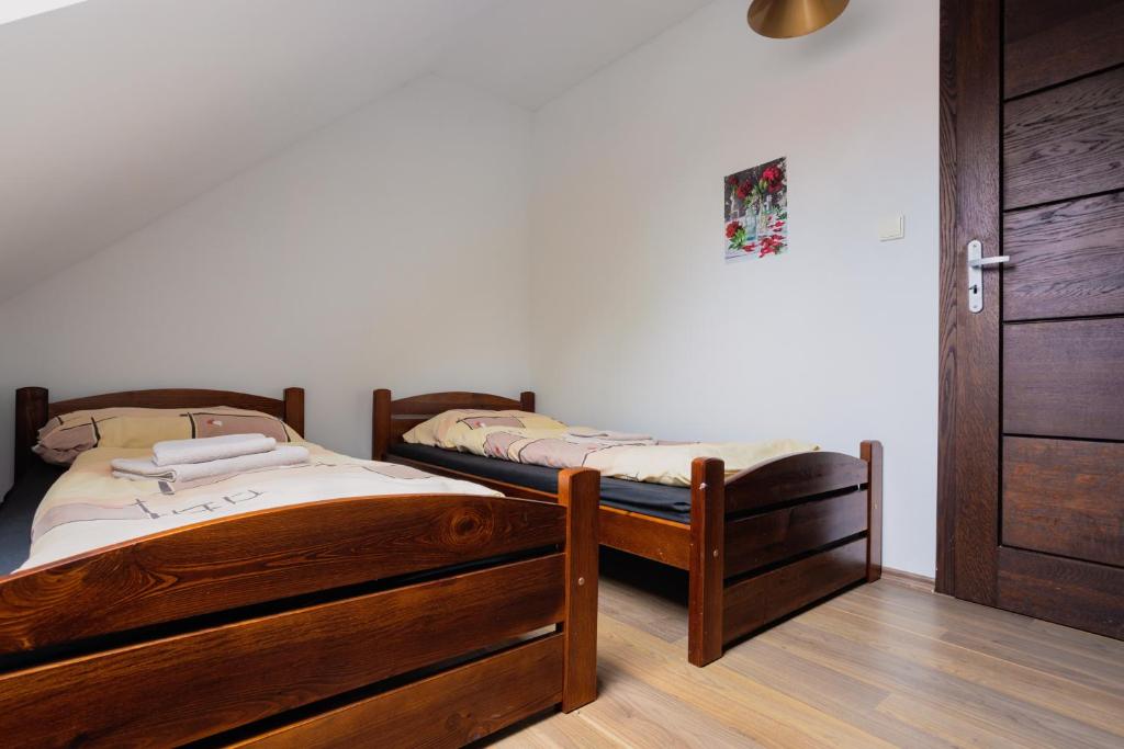 two wooden beds in a room with a door at Apartments in the historic part of Znojmo in Znojmo