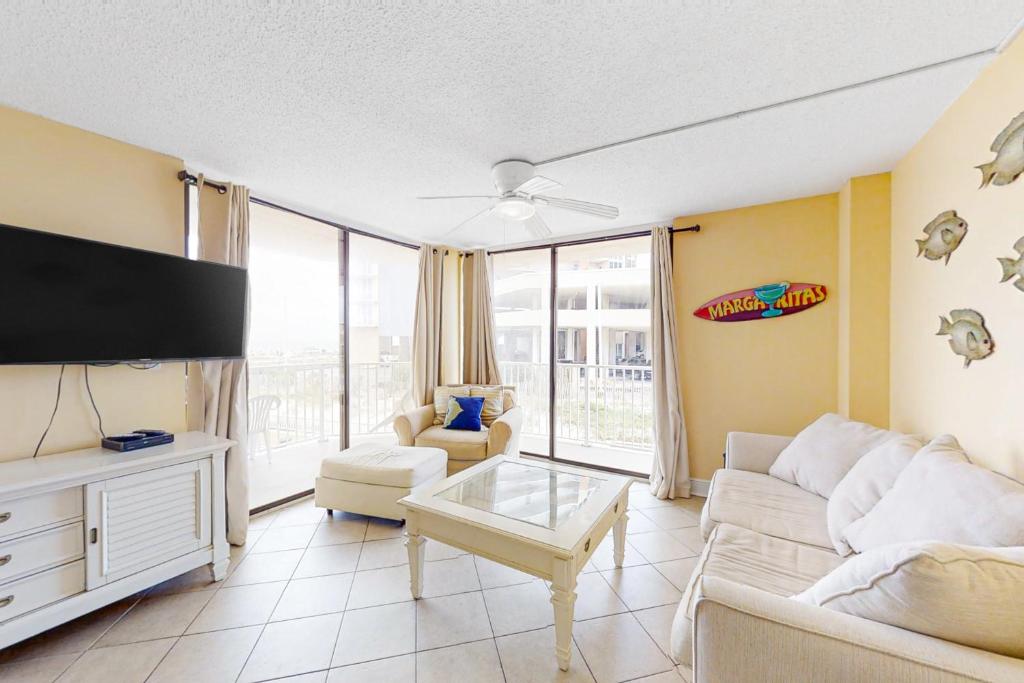 uma sala de estar com um sofá e uma televisão de ecrã plano em The Whaler 1A em Gulf Shores