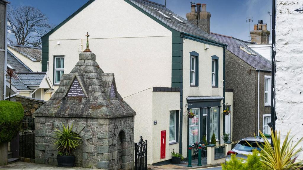 a white building with a cross on top of it at Hen Bost Nefyn in Nefyn