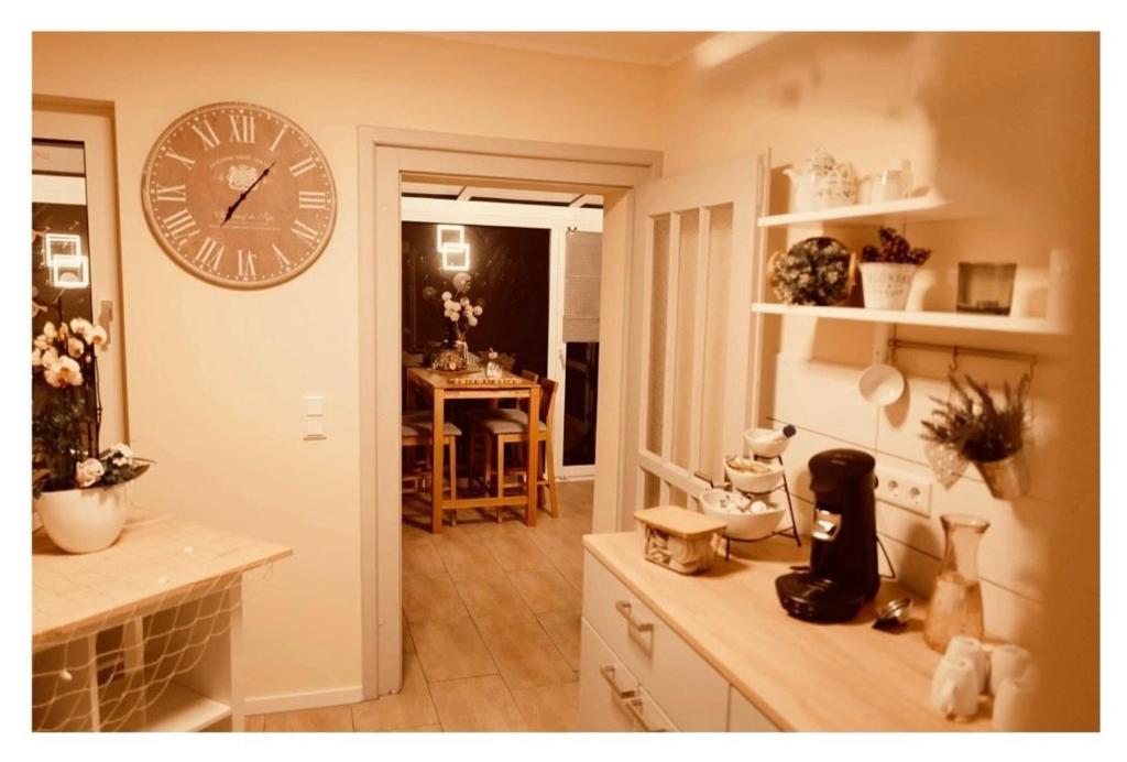 a kitchen with a large clock on the wall at Hotel Pension garni Haus am Strand 2 in Norddeich