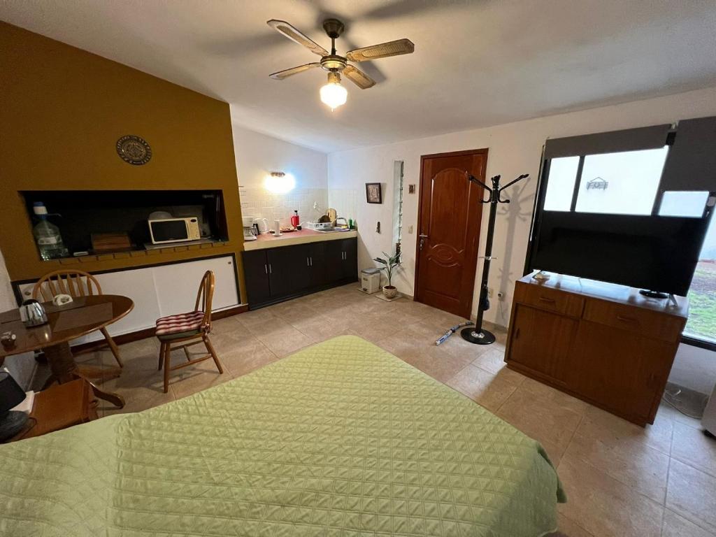 a bedroom with a bed and a kitchen with a table at Linda casa en Barra de Carrasco in Montevideo