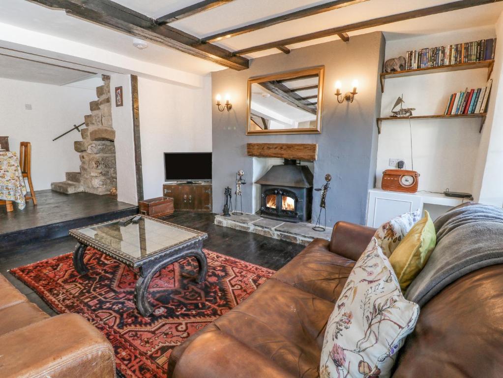 a living room with a couch and a fireplace at Tinners in Gunnislake