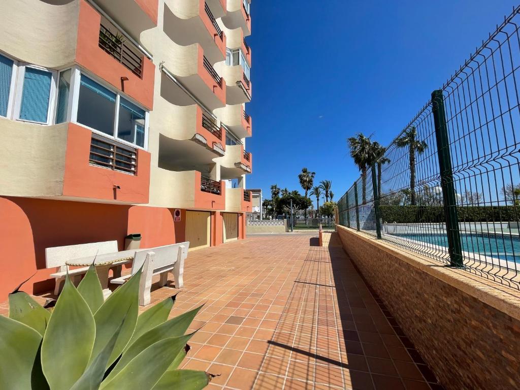 a brick walkway next to a building with a pool at Alpen1 Europeñiscola in Peñíscola