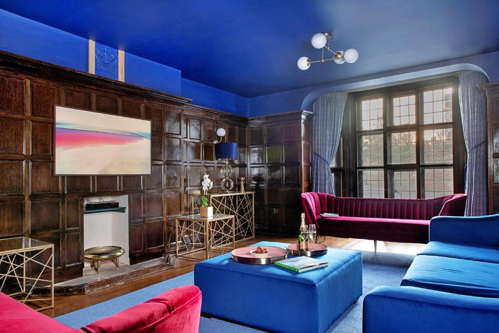 a living room with blue and red furniture at Finest Retreats - Castle House Nottingham - Luxurious Hot Tub Stay in Nottingham