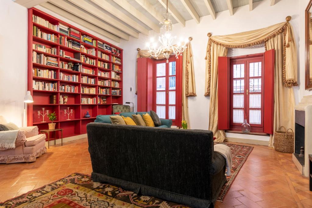 sala de estar con sofá y estanterías en EXCLUSIVA CASA EN EL CENTRO HISTORICO de SEVILLA en Sevilla