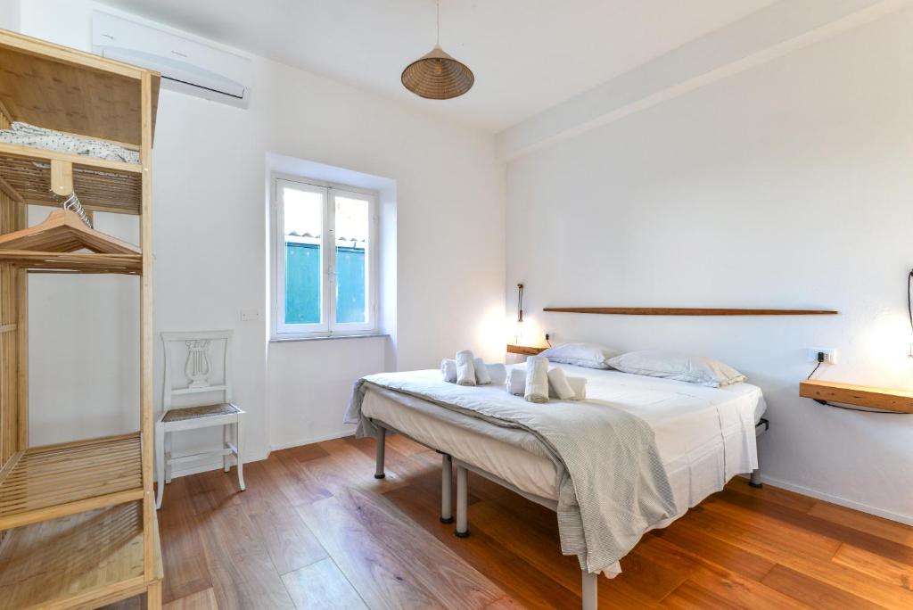 a white bedroom with a bed and a window at Casa Magnolia in Campo nell'Elba