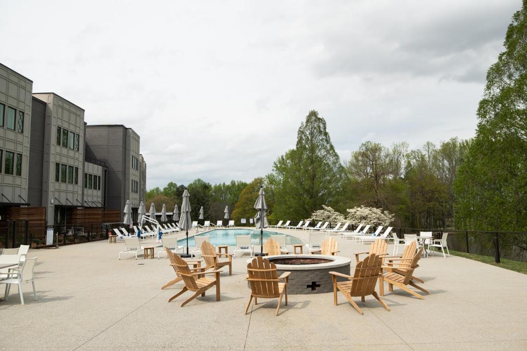 a patio with chairs and a table and a pool at Hotel Hartness in Greenville