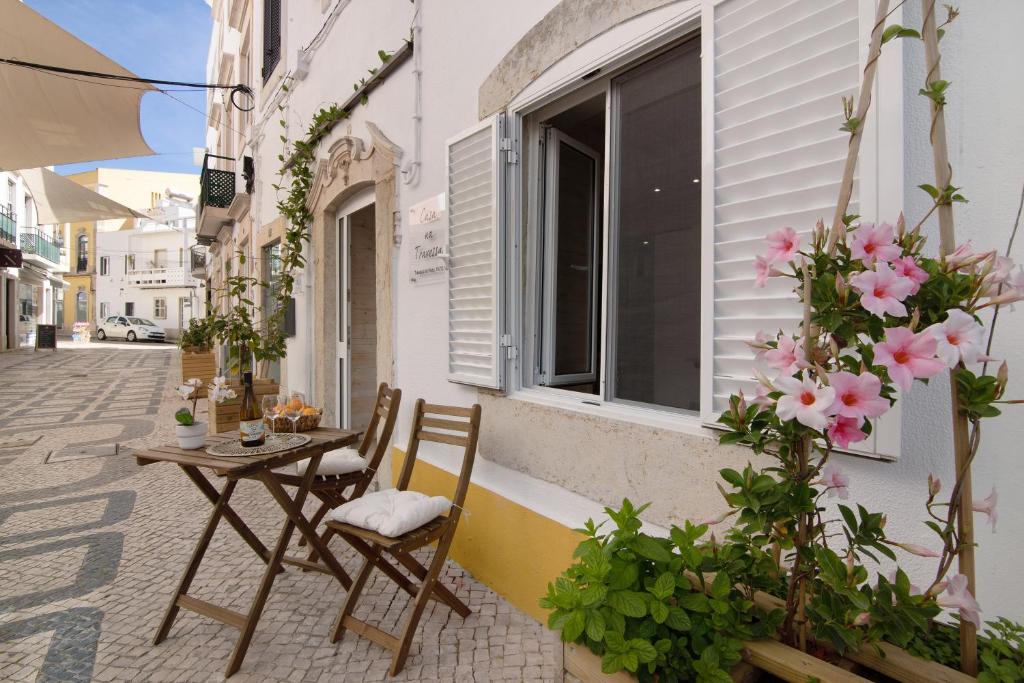 un tavolo e sedie sul lato di un edificio fiorito di Casa na Travessa 2 a Faro