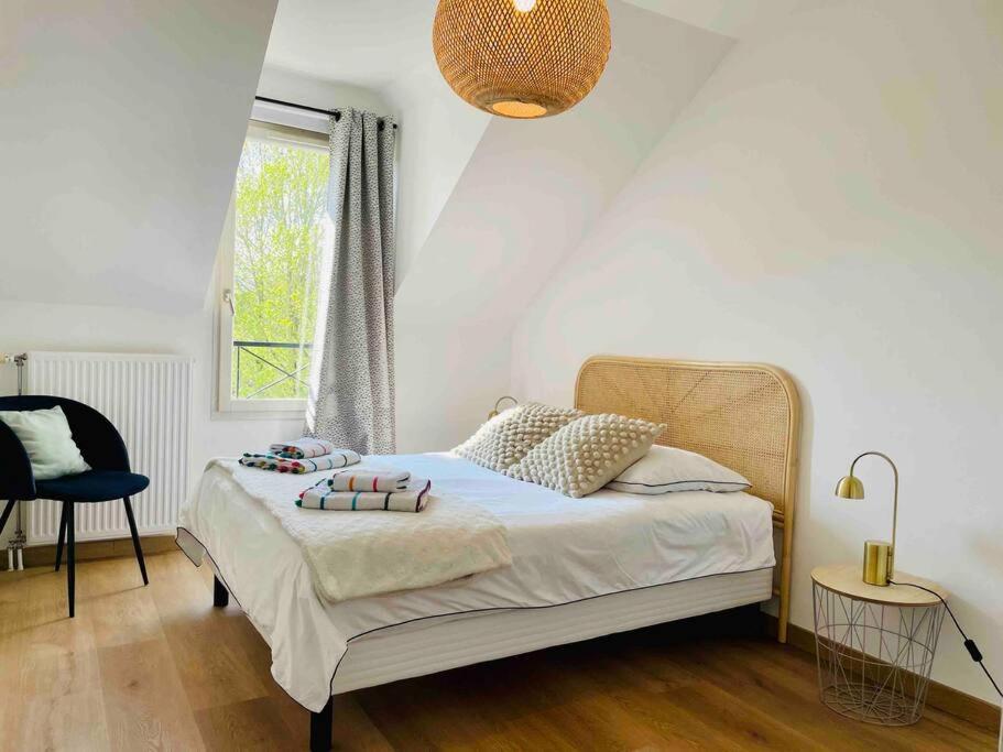 a bedroom with a bed and a chair and a window at Marne la Vallée Apartment in Serris