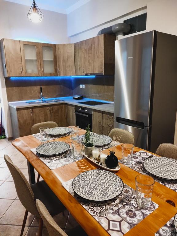 a kitchen with a wooden table with chairs and a refrigerator at Avanda Corfu in Corfu Town