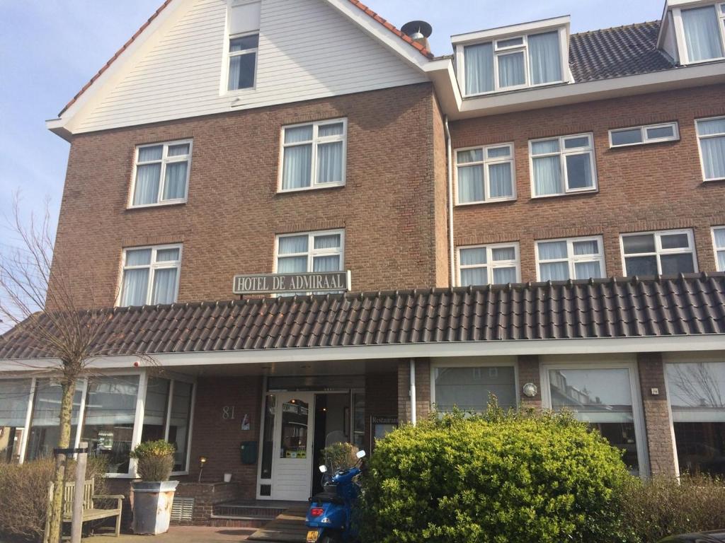 een bruin bakstenen huis met een wit dak bij Hotel de Admiraal in Noordwijk aan Zee