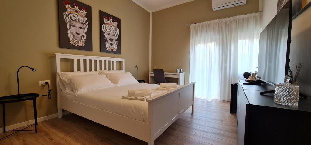1 dormitorio con cama blanca y ventana en Di Fresco Apartments - Holiday House, en Palermo