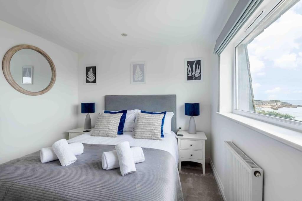 - une chambre blanche avec 2 lits et une fenêtre dans l'établissement Little Haven St Ives, à St Ives