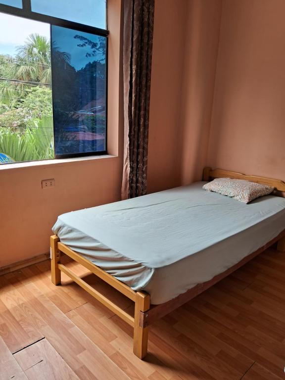 Bett in einem Zimmer mit Fenster in der Unterkunft Casa sanacion Elixir in Pucallpa