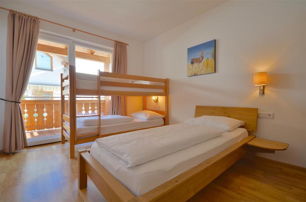 a bedroom with two bunk beds and a balcony at Apartment Igor - by Alpen Apartments in Piesendorf
