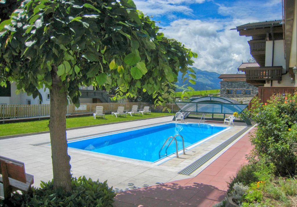 una piscina con un árbol en un patio en Select Top 10 - by Alpen Apartments, en Piesendorf