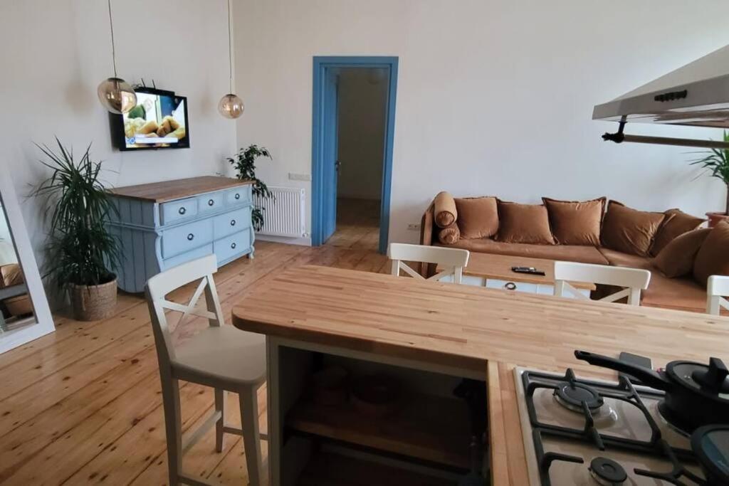 een woonkamer met een bank en een tafel bij Home away from home in Tbilisi City