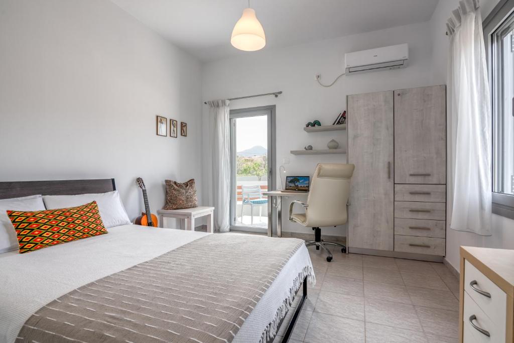 a bedroom with a bed and a desk and a window at Lahardi - Seaside House in Kissamos
