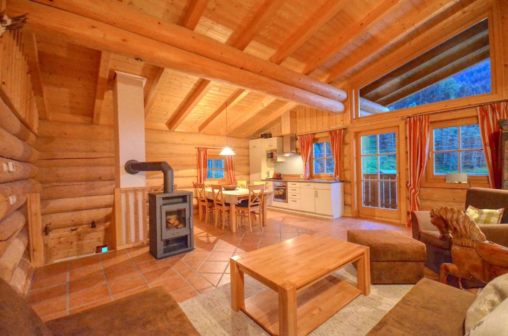a living room with a fireplace in a log cabin at Chalet Stabler - by Alpen Apartments in Zell am See