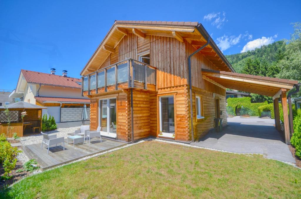 una casa de madera con césped delante en Chalet Seven - by Alpen Apartments, en Zell am See