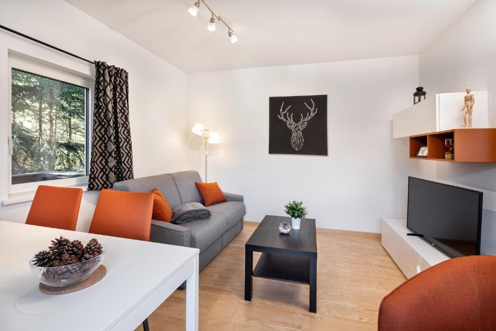 salon z kanapą i stołem w obiekcie Mozart Top 2 - by Alpen Apartments w mieście Zell am See