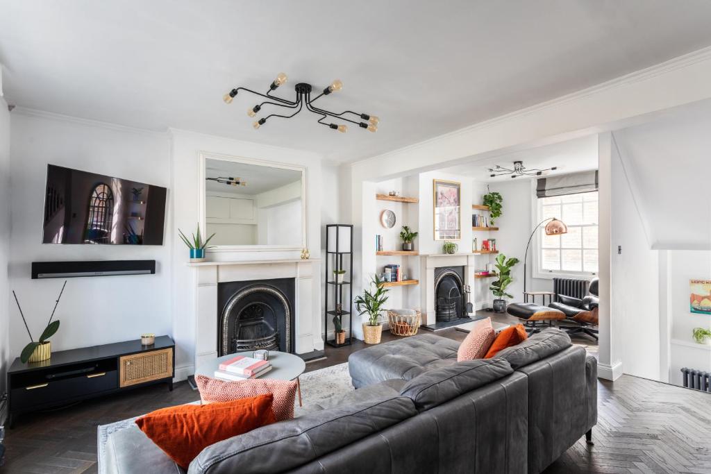 a living room with a couch and a fireplace at Stunning Townhouse with large roof terrace in London