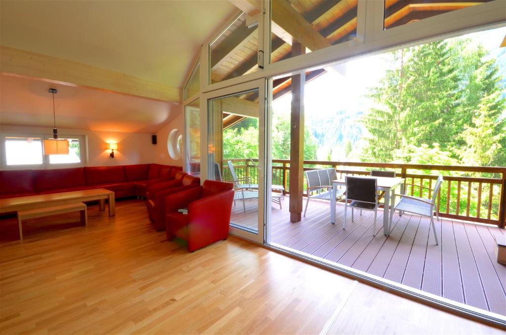 een woonkamer met een rode bank en een tafel bij Penthouse Cooper - by Alpen Apartments in Bad Gastein