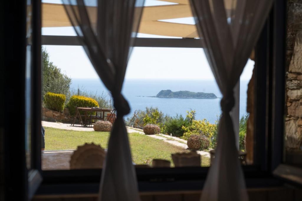 a view of the ocean from a window at Wonderful maisonette overlooking the Aegean Sea in Petriaí