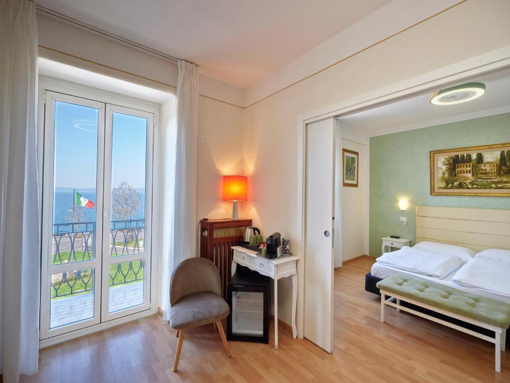 a bedroom with a bed and a large window at Hotel San Marco in Garda