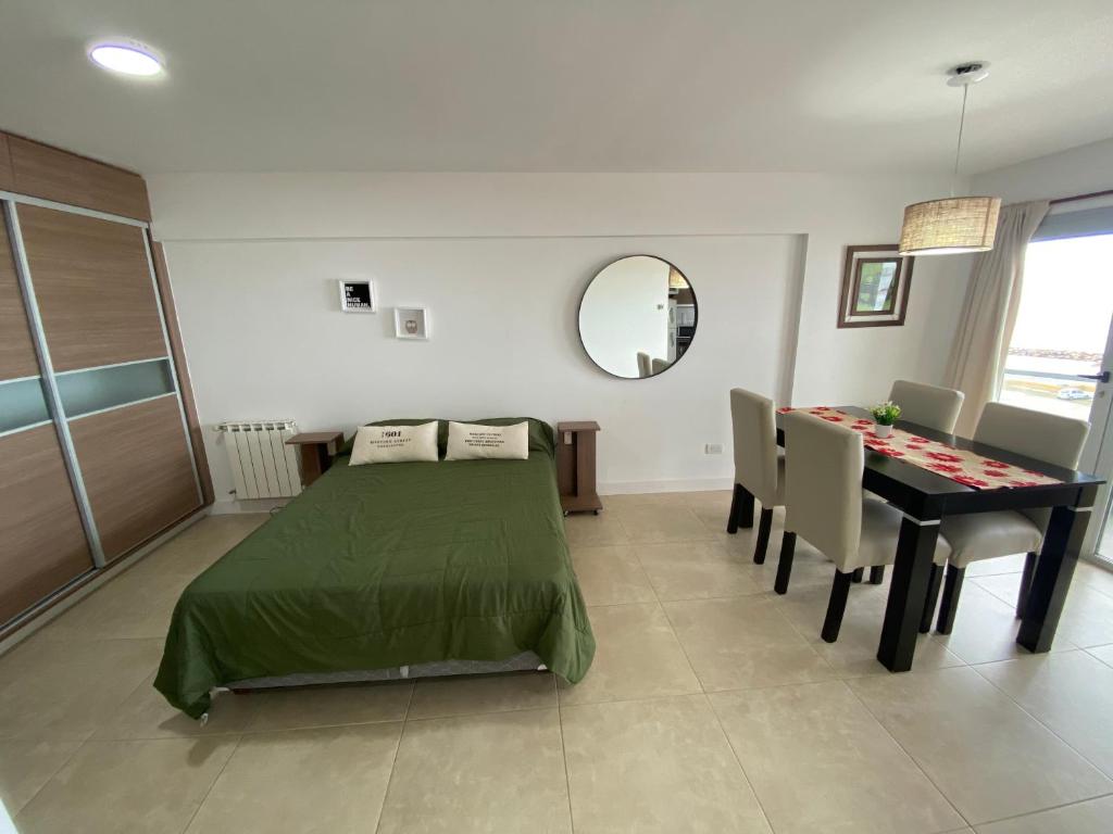 a bedroom with a bed and a table with chairs at Departamentos Eneas Frente al Mar in Mar del Plata