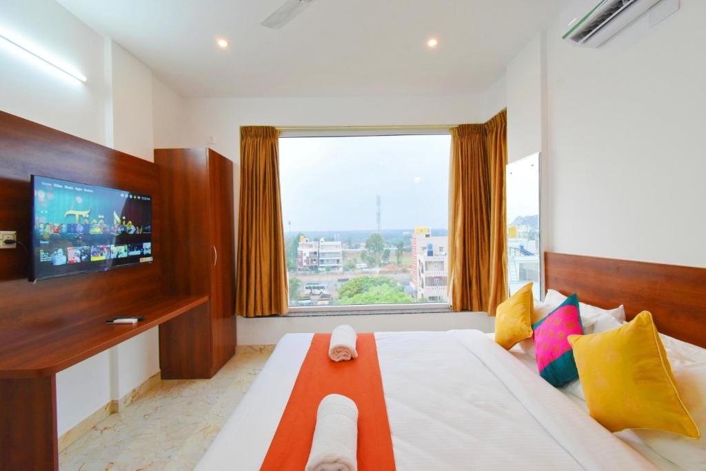 耶拉汉卡Keerthis Royal Suites - Near International Airport Terminal 1 and 2的一间带大床和大窗户的卧室