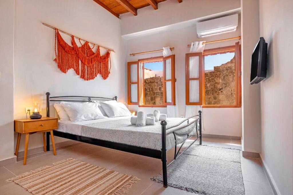 a bedroom with a bed and a tv and windows at Casa Della vita apartment ,Old Town Rhodes in Rhodes Town