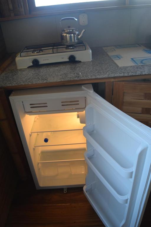 an empty refrigerator with its door open in a kitchen at Bungalows Ayampe in Ayampe