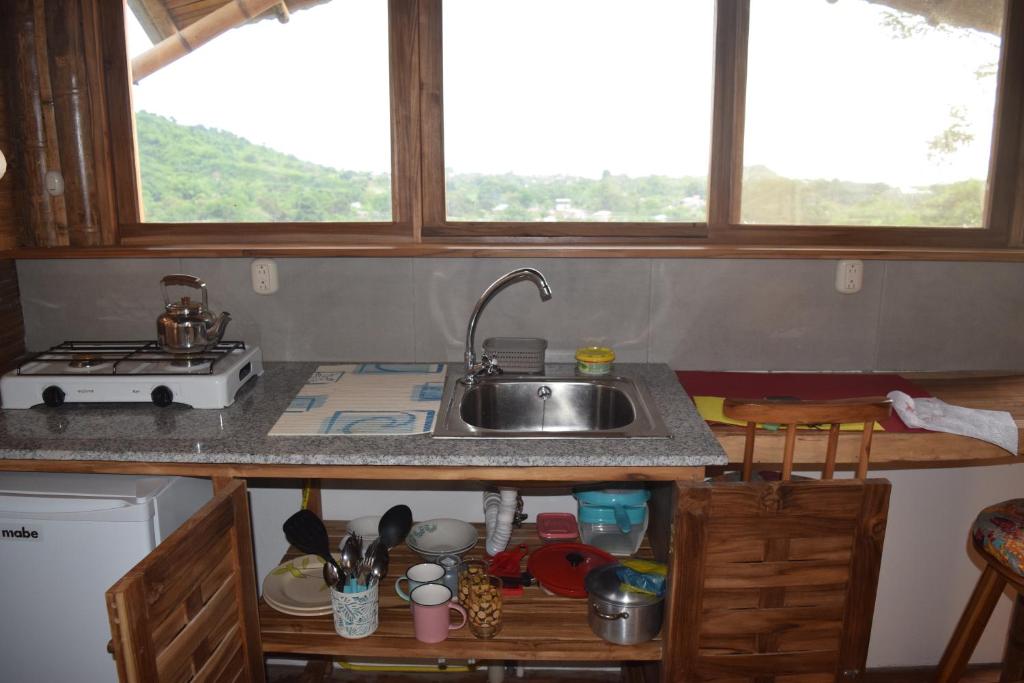 a kitchen with a sink and two windows at Bungalows Ayampe in Ayampe