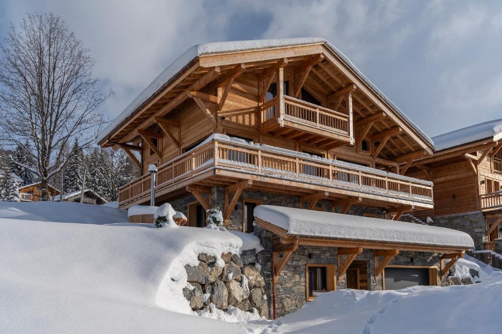 une cabane en rondins en hiver avec de la neige autour de celle-ci dans l'établissement Chalet Folie Douce, aux Gets
