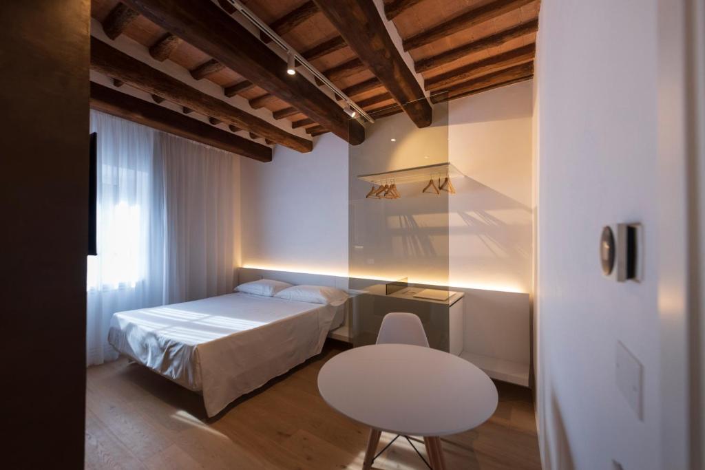 Un dormitorio con una cama, una mesa y una silla. en Terra d'Ombra Bed&Breakfast, en San Gimignano