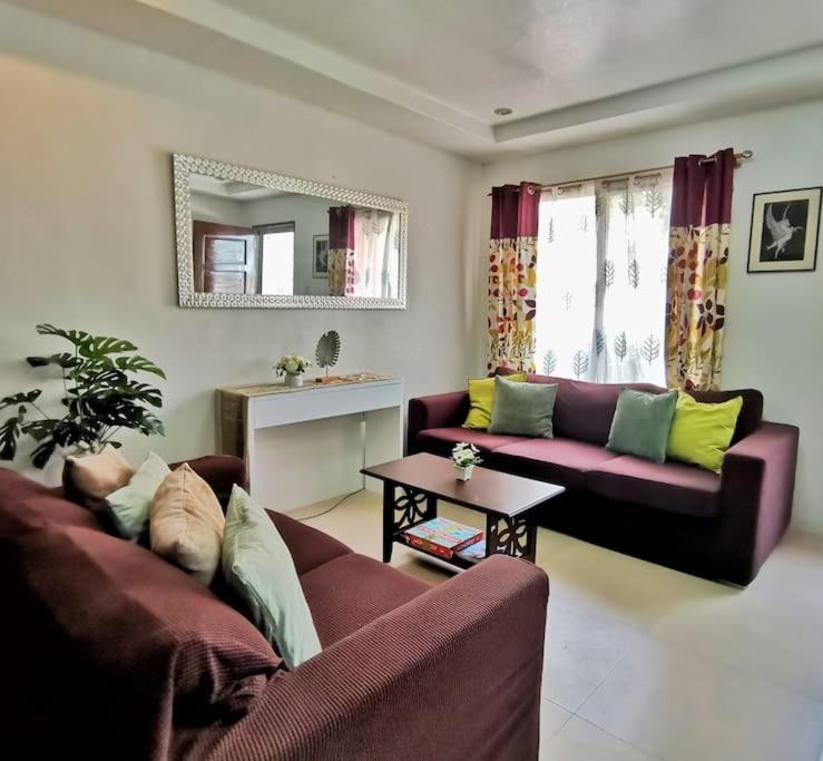 uma sala de estar com dois sofás e uma mesa em 2BR 2BT home with pool between Tagbilaran and Panglao em Dauis