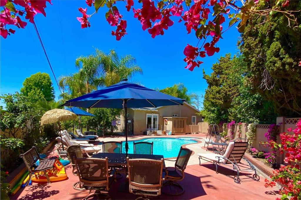 a patio with chairs and an umbrella and a pool at Disneyland Paradise 6 BedRoom 4 Bathroom Pool Spa Games in Anaheim