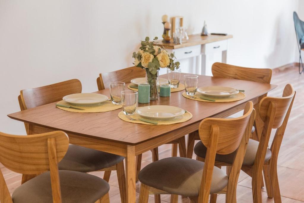 聖拉斐爾的住宿－Depto 514，一张木桌,配有椅子和盘子及玻璃杯
