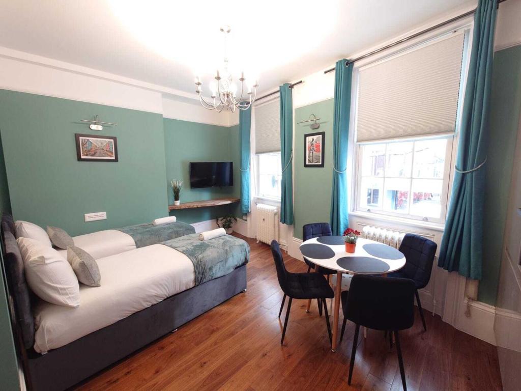 1 dormitorio con 1 cama, mesa y sillas en Kings Cross Apartment, en Londres