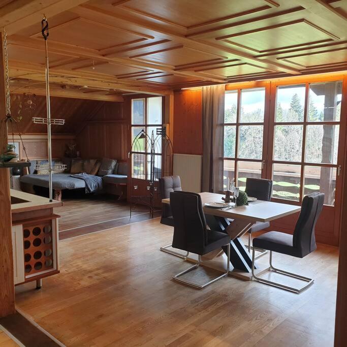 a room with a table and chairs and a living room at Ferienwohnung Fam. Biechele in Rückholz