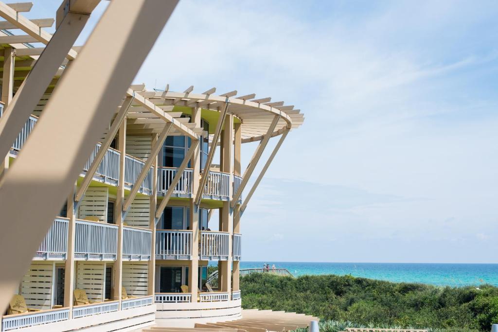a building on the beach with the ocean in the background at WaterColor Inn & Resort in Santa Rosa Beach