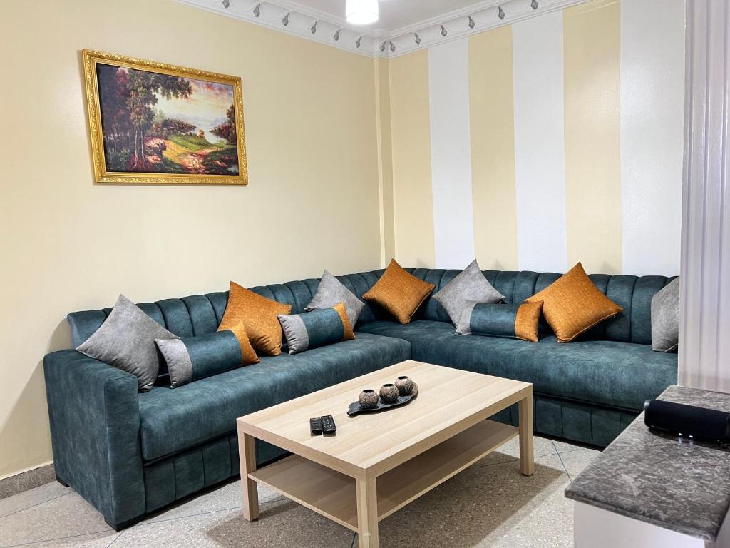 - un salon avec un canapé bleu et une table basse dans l'établissement T3 beautiful apartment for rent, à Martil