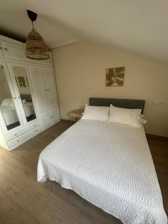 a bedroom with a white bed with a white comforter at La Estación in Avilés