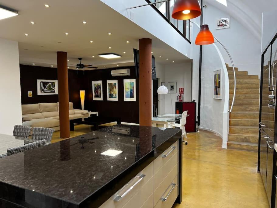 a kitchen with a counter top and a living room at Espectacular Loft en pleno centro de Alcázar. in Alcazar de San Juan