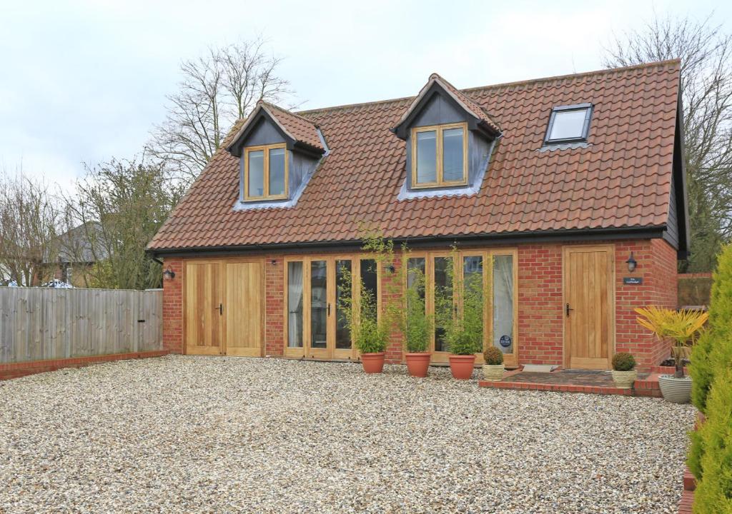 a red brick house with a roof at The Cartlodge in Sudbury