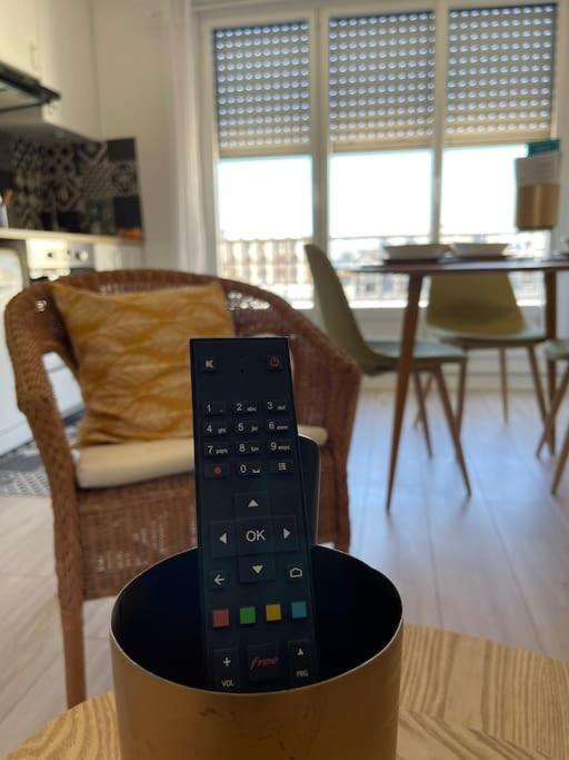 a remote control sitting on a table in a living room at APPARTEMENT COSY Balcon à 30min de PARIS in Cergy