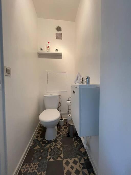 a bathroom with a white toilet and a sink at APPARTEMENT COSY Balcon à 30min de PARIS in Cergy