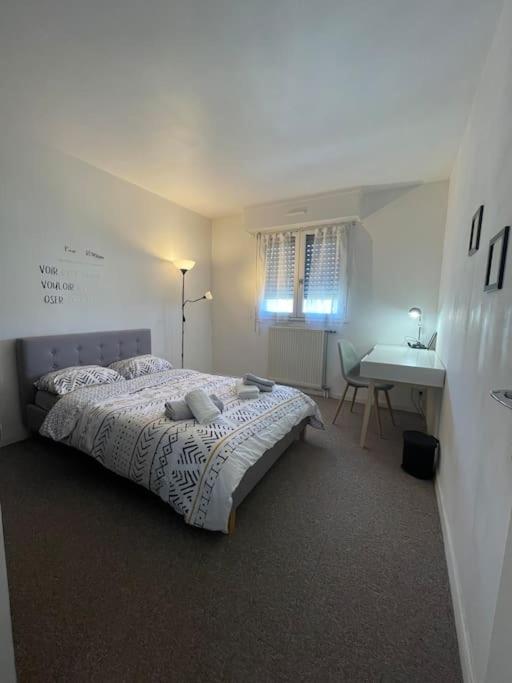 a white bedroom with a bed and a desk at APPARTEMENT COSY Balcon à 30min de PARIS in Cergy