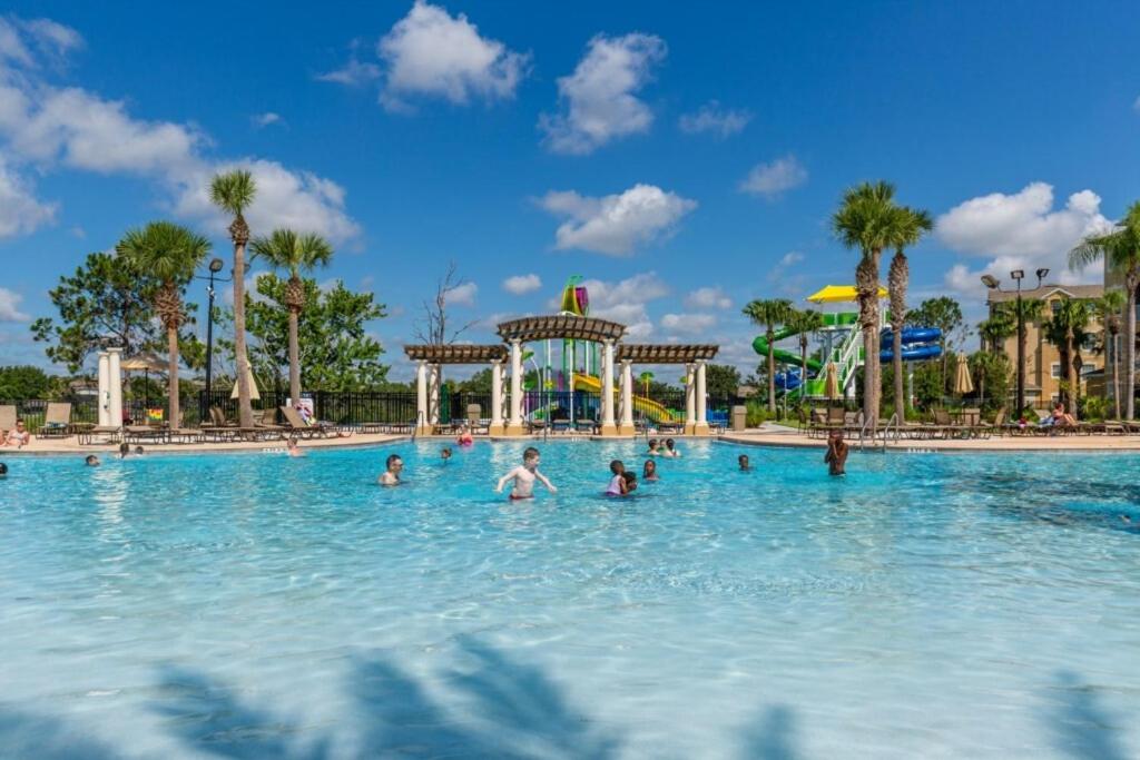 a group of people in a swimming pool at a theme park at GROUND FLOOR OVERSIZED CONDO - NEXT TO DISNEY! #104 in Orlando